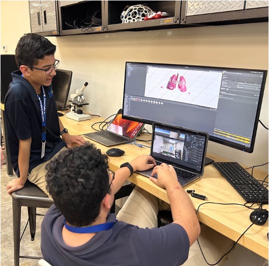 Students designing a virtual reality rehabilitation environment on a workstation with 3D models of human anatomy