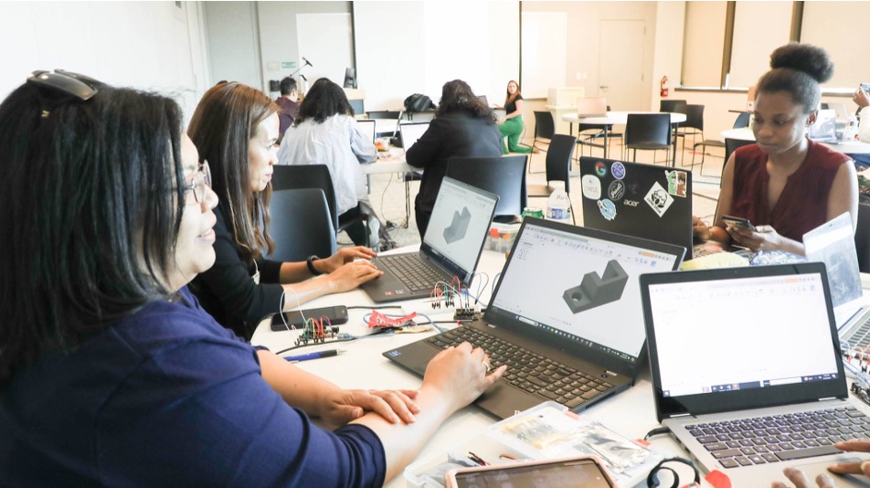 Teachers working on CAD models and microcontroller kits in a hands-on session