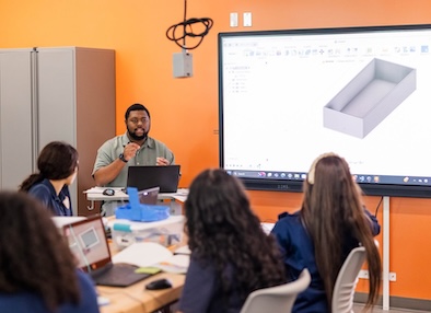 Students using computer-aided design software to model precise engineering drawings